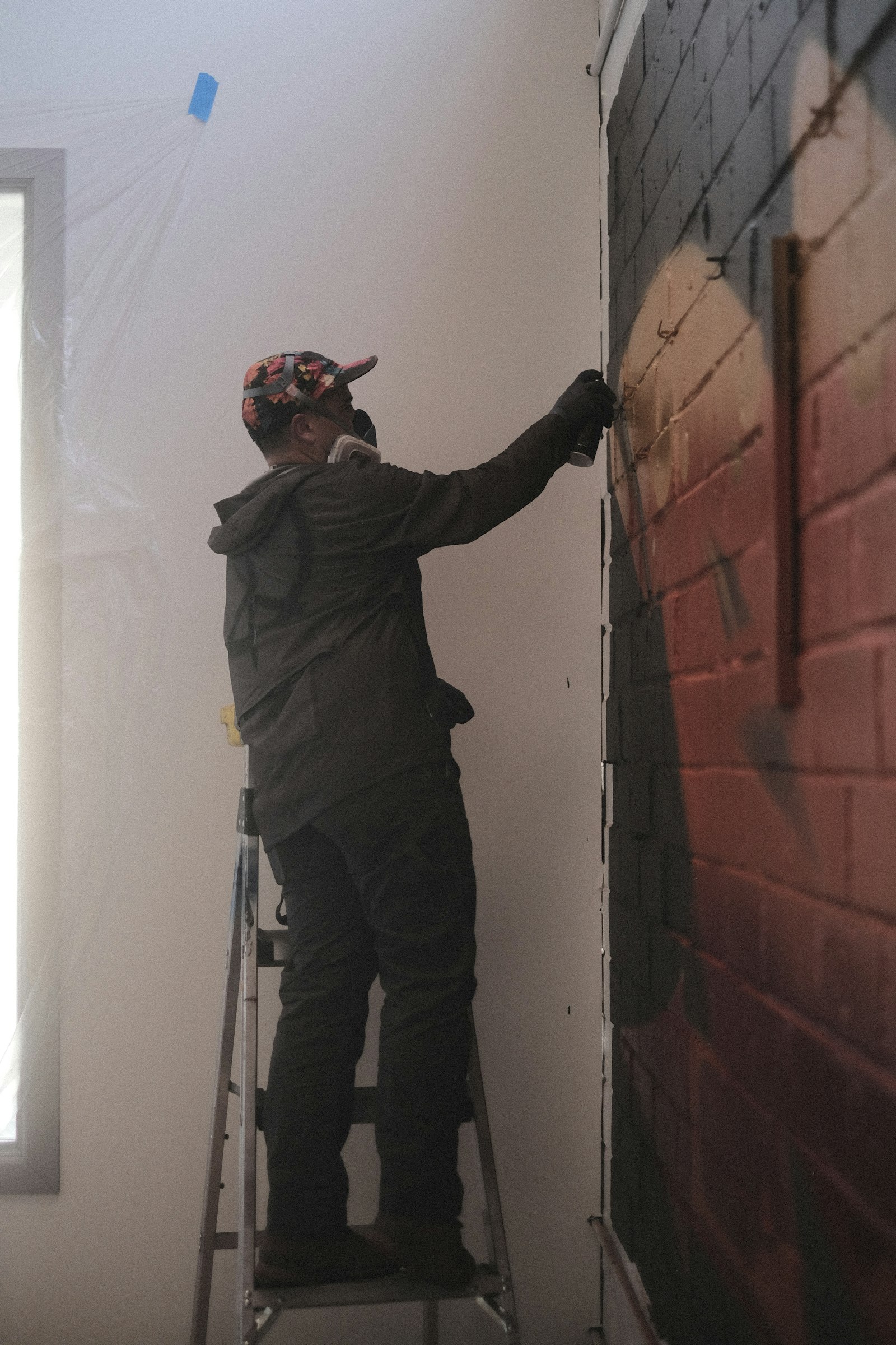 Vakman werkt een wand af op hoogte