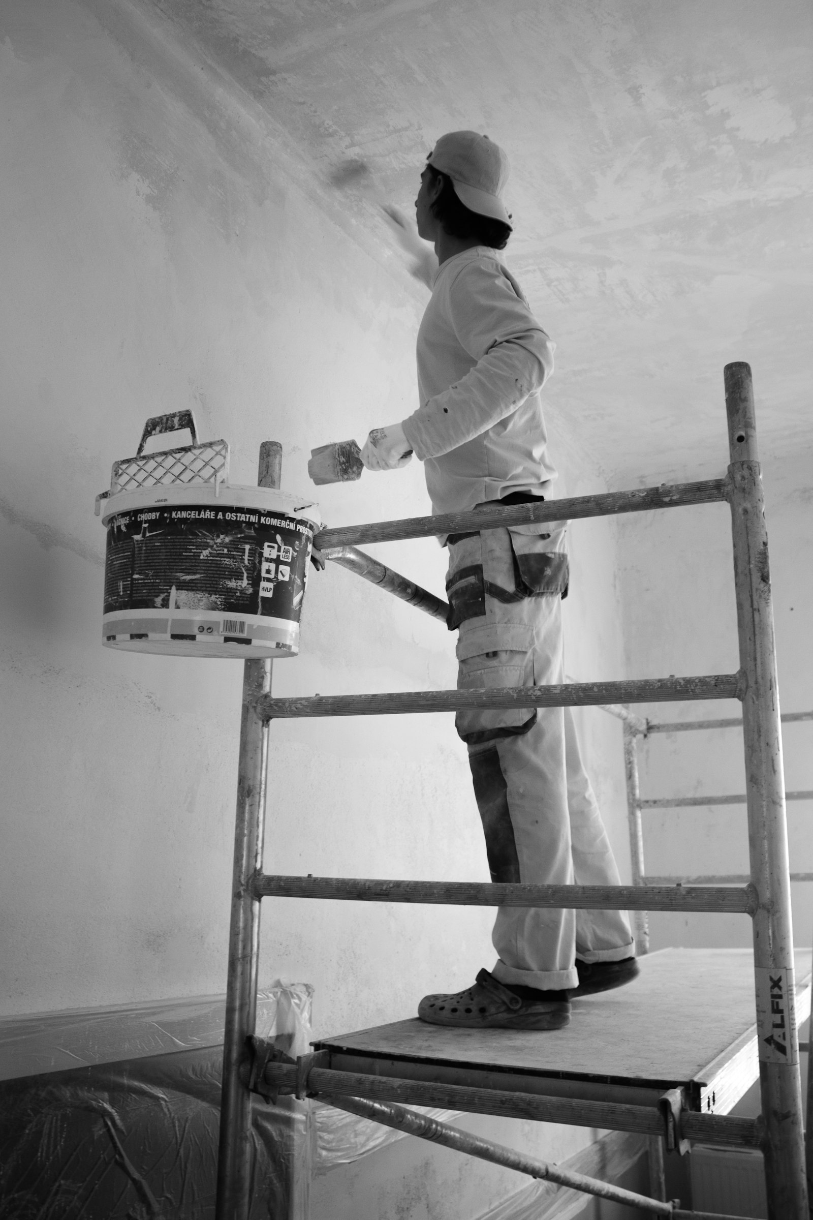 Schilder werkt een binnenmuur af met een roller